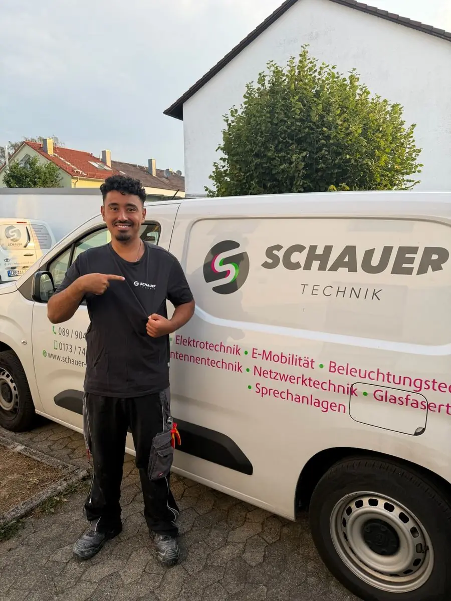 Monteur von Schauer Technik vor dem beschrifteten Firmenfahrzeug