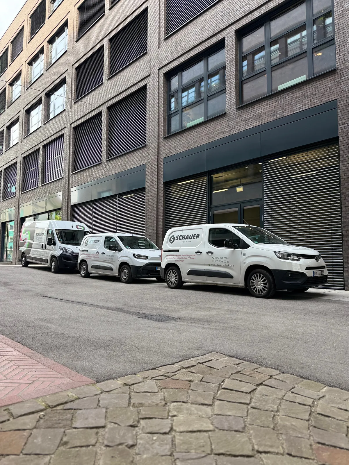 Fahrzeuge von Schauer Technik vor einem Gewerbeobjekt